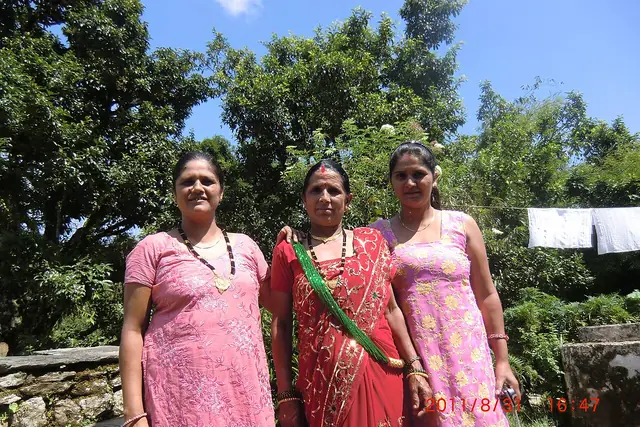 Women in red saris on their way to a Teej gathering